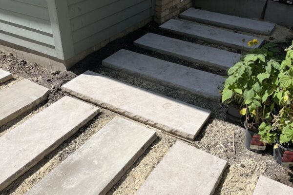 The connection between two perpendicular paver paths, each made from 14” x 48” Indiana limestone pavers set into a sand base.