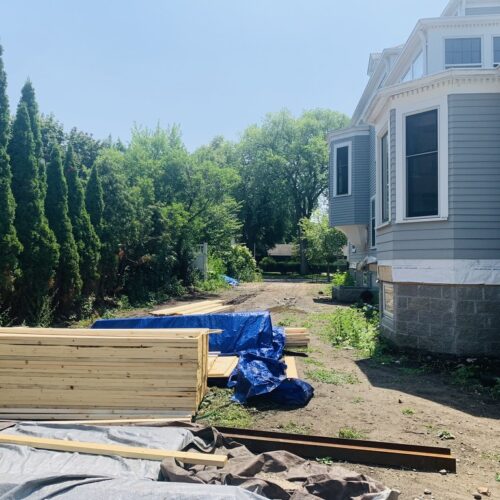 The narrow side yard of a stately Neo-Georgian home in the Kenwood neighborhood of Minneapolis, has been stripped of turf and shows signs of continued construction.