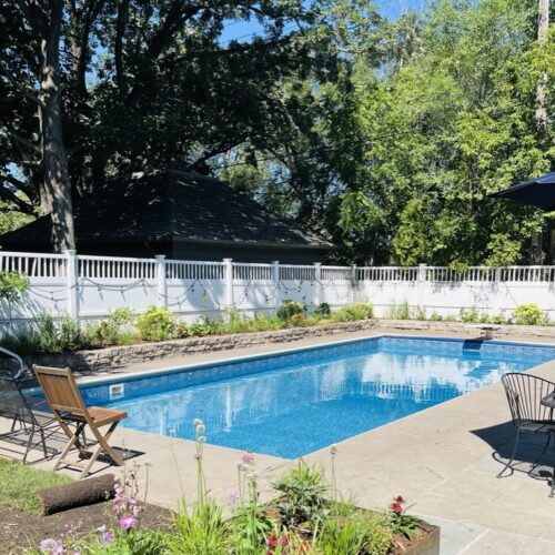 On a summer day in the Kenwood neighborhood of Minneapolis, an in-ground pool, surrounded by brightly colored cottage-style planting beds, glistens in the sun.